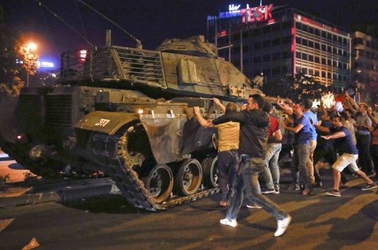 People react near a military vehicle during an attempted coup in Ankara